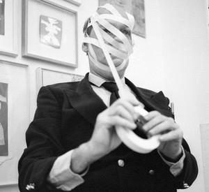 Schwarz-weiß Fotografie eines Mannes, der Klebeband um den Kopf gewickelt hat