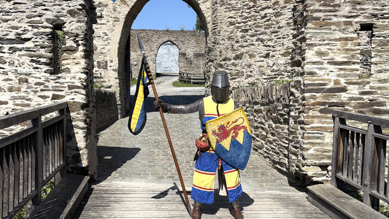 Gewandeter Ritter vor einem Burgtor