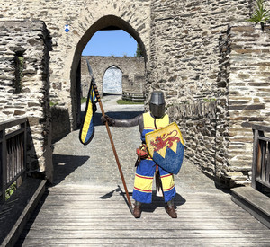 Gewandeter Ritter vor einem Burgtor